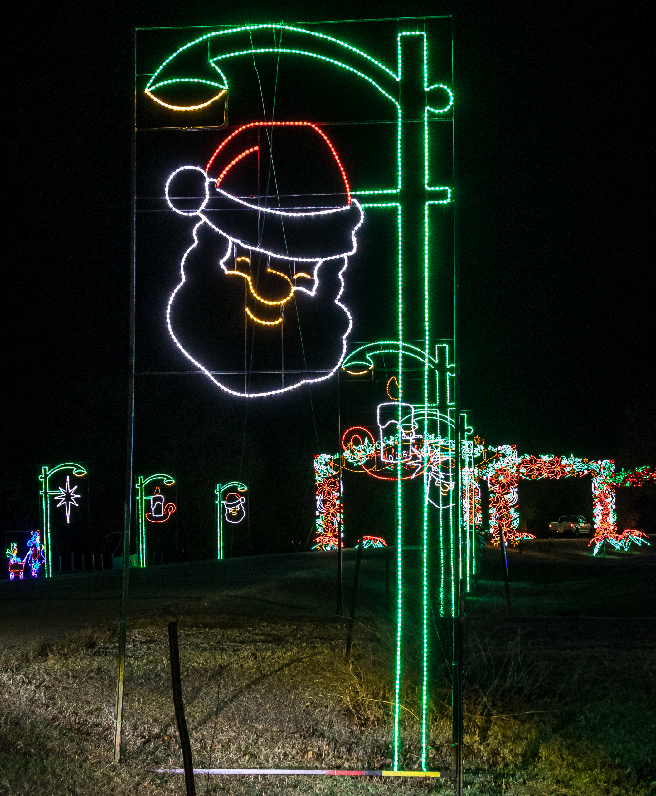 Santa Claus lamppost display glowing on the drive at Lights of Joy in Branson