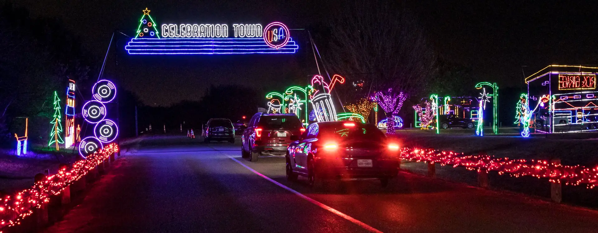 Cars driving through the Celebration Town displays at Lights of Joy in Branson, MO
