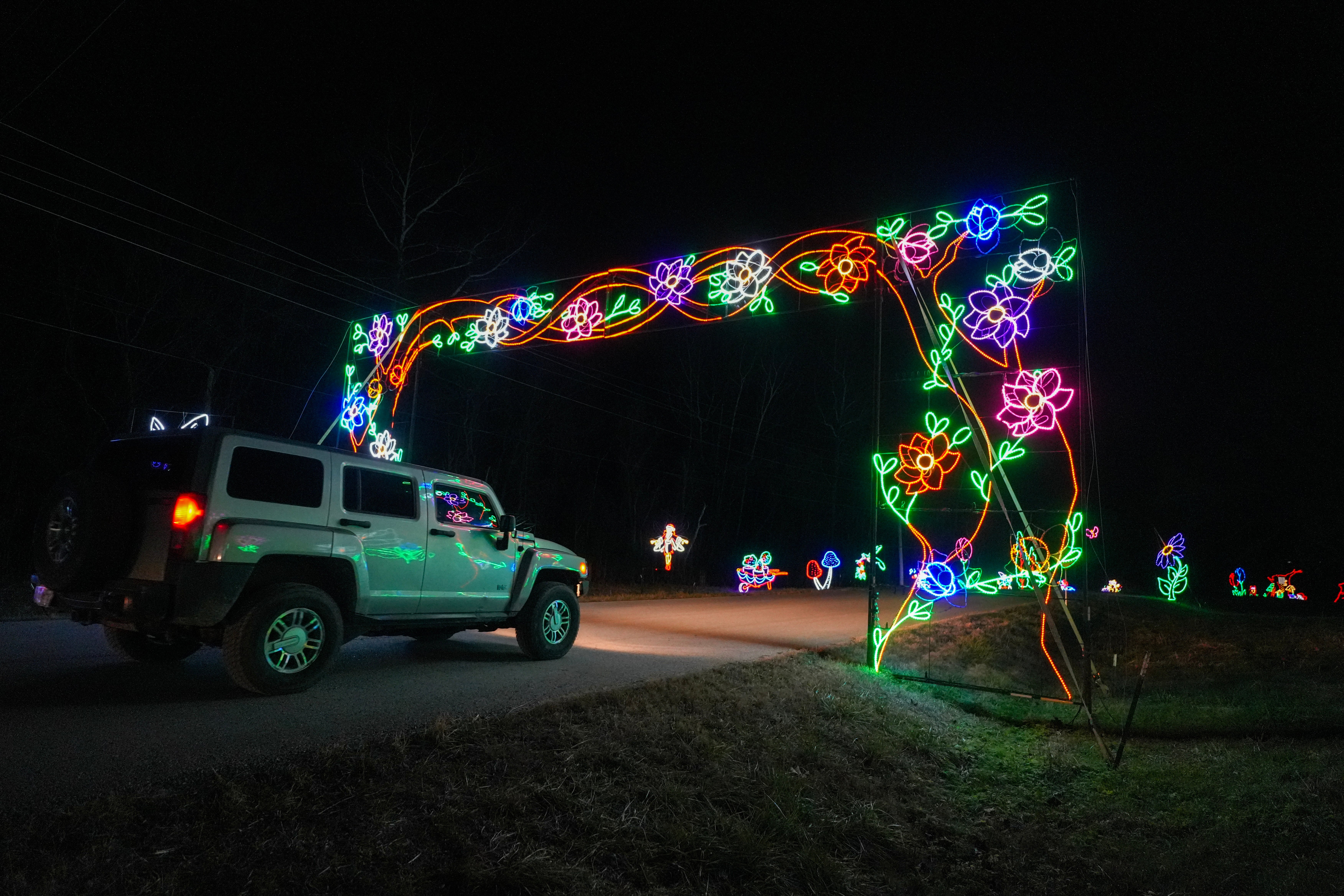 Car passing under a lit archway at Lights of Joy Christmas Drive-Thru in Branson