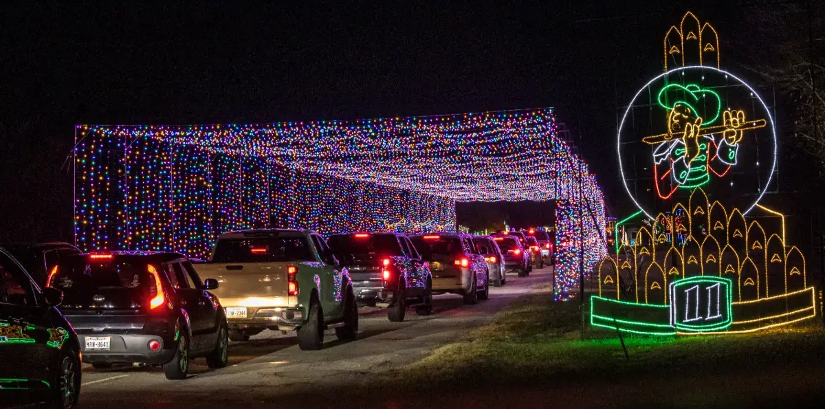 Cars driving through the RGB Digital Tunnel at Lights of Joy Christmas Drive-Thru in Branson, MO