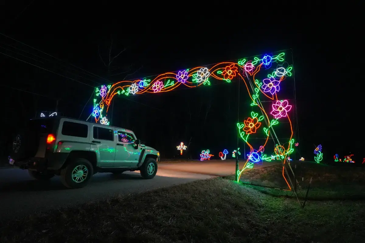 Car passing under a lit archway at Lights of Joy Christmas Drive-Thru in Branson